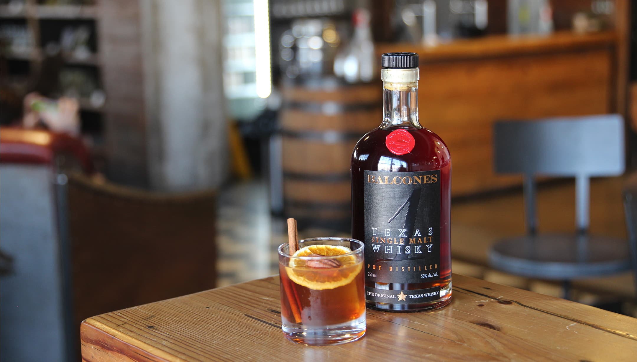 Bottle of TEXAS 1 with a glass of SWEET RATIFICATION cocktails on table