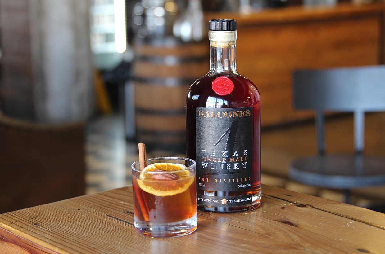 Bottle of TEXAS 1 with a glass of SWEET RATIFICATION cocktails on table