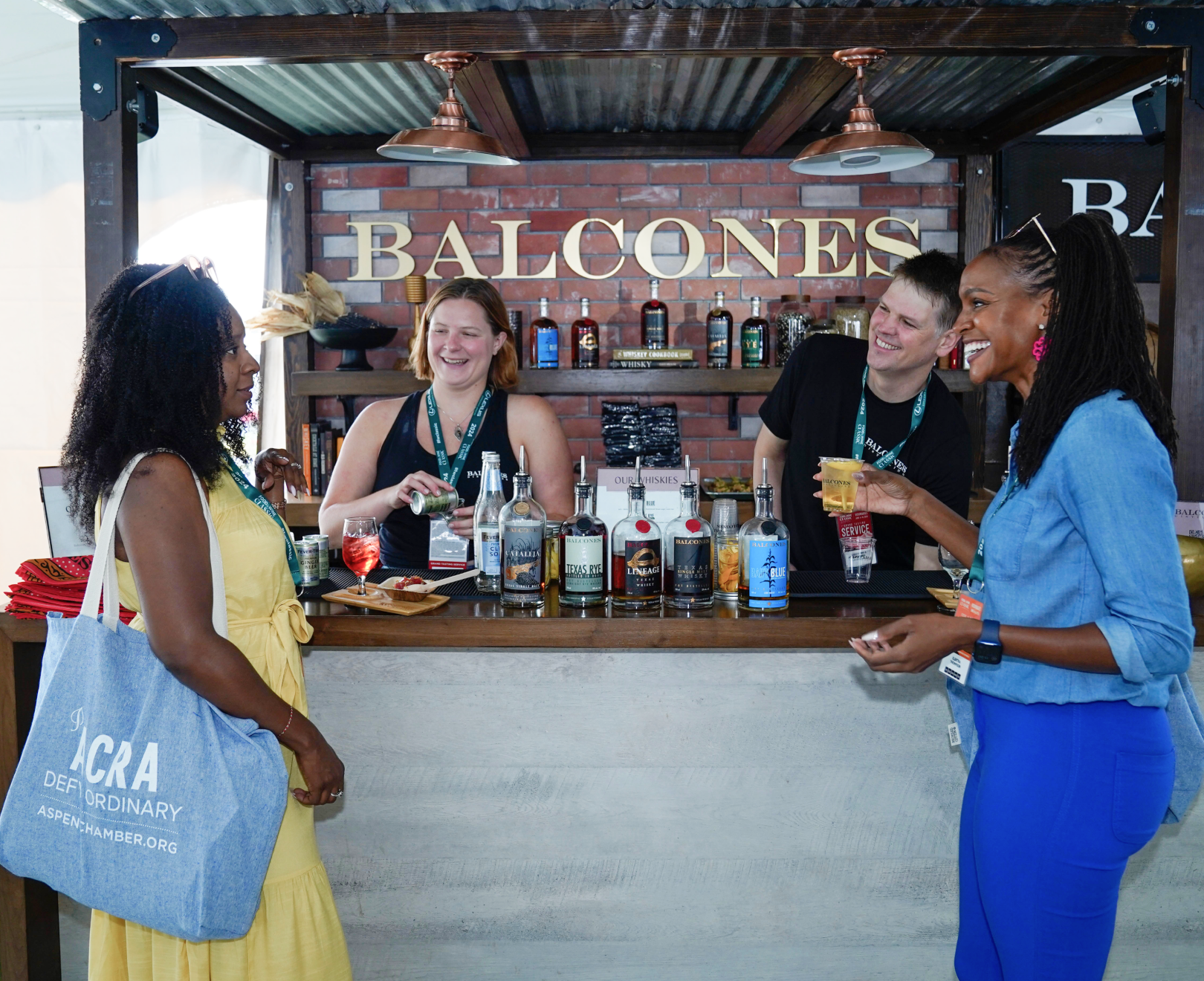 Two women laughing and talking at the Balcones' bar