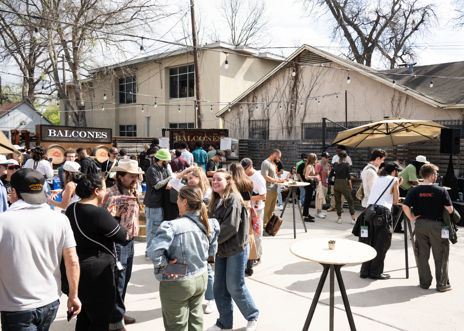 Wide shot of event with multiple vendors and crowd of people
