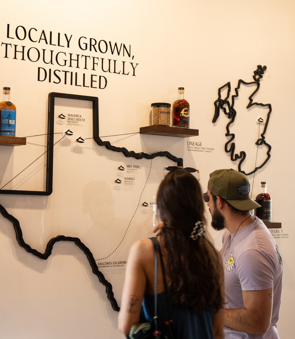Two people viewing map of Texas on the wall with ""Locally Grown